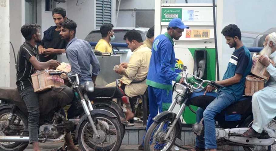 People getting their fuel tanks filled with petrol at a gas pump in Karachi,