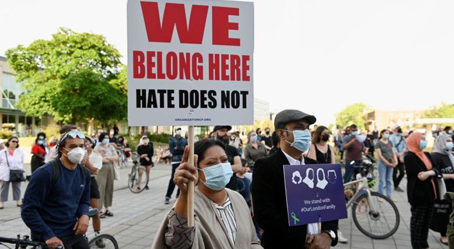 People hold up signs during a vigil in memory of a Muslim family that was killed in London, Ontario. Source: Reuters