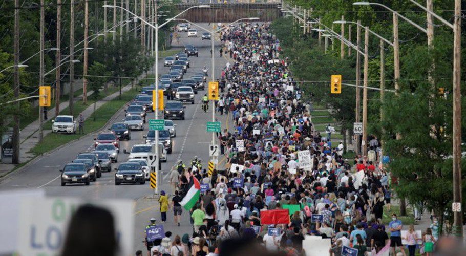People march from a crime scene to a mosque in memory of a Muslim family that was killed a hate-motivated attack. Source: Reuters