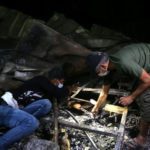 People inspect the damage at the site where a fire broke out at a coronavirus hospital. Source: Reuters.