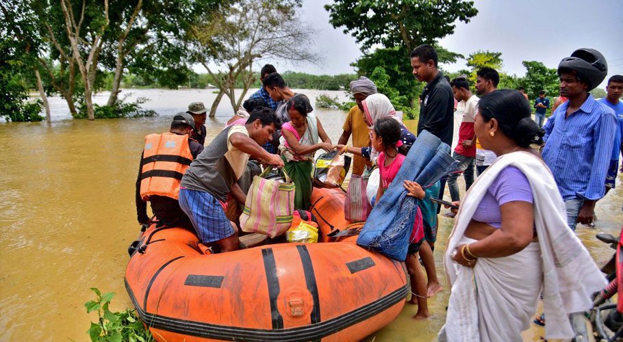 People disembark a boat after they were evacuated from a flooded village