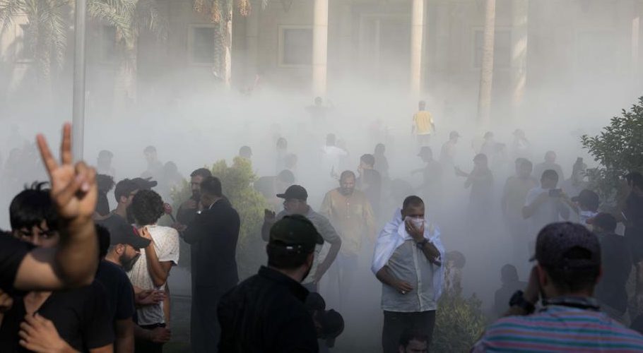 Iraqi security forces fire tear gas on followers of Shiite cleric Muqtada al-Sadr protesting inside the government palace grounds, in Baghdad, Iraq, Monday, Aug. 29, 2022. (AP Photo/Hadi Mizban)