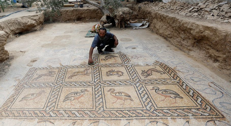 Palestinian farmer Salman al-Nabahin cleans a mosaic floor he discovered at his farm and which dates back to the Byzantine era, according to officials, in the central Gaza Strip September 18, 2022. REUTERS/Ibraheem Abu Mustafa