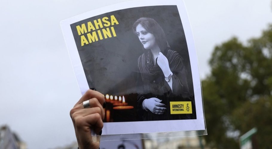 FILE - A protester shows a portrait of Mahsa Amini during a demonstration to support Iranian protesters standing up to their leadership over the death of a young woman in police custody, Sunday, Oct. 2, 2022 in Paris