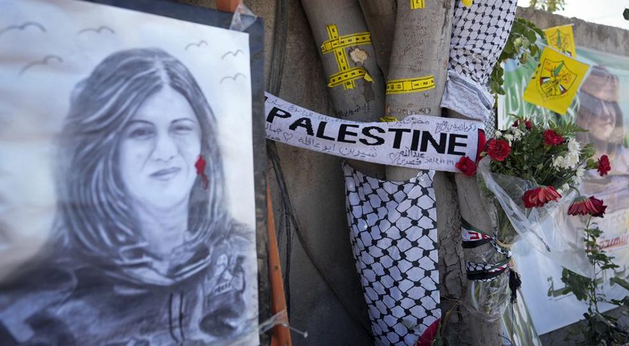 FILE - Yellow tape marks bullet holes on a tree and a portrait and flowers create a makeshift memorial, at the site where Palestinian-American Al-Jazeera journalist Shireen Abu Akleh was shot and killed in the West Bank city of Jenin, May 19, 2022. (AP Photo/Majdi Mohammed, File)