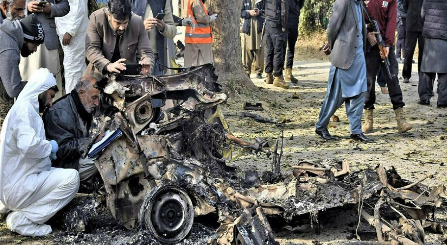 Forensic officials collect evidence from the smoldering wreckage of the explosives-laden vehicle in which suicide bombers were traveling in Islamabad. PHOTO: ONLINE