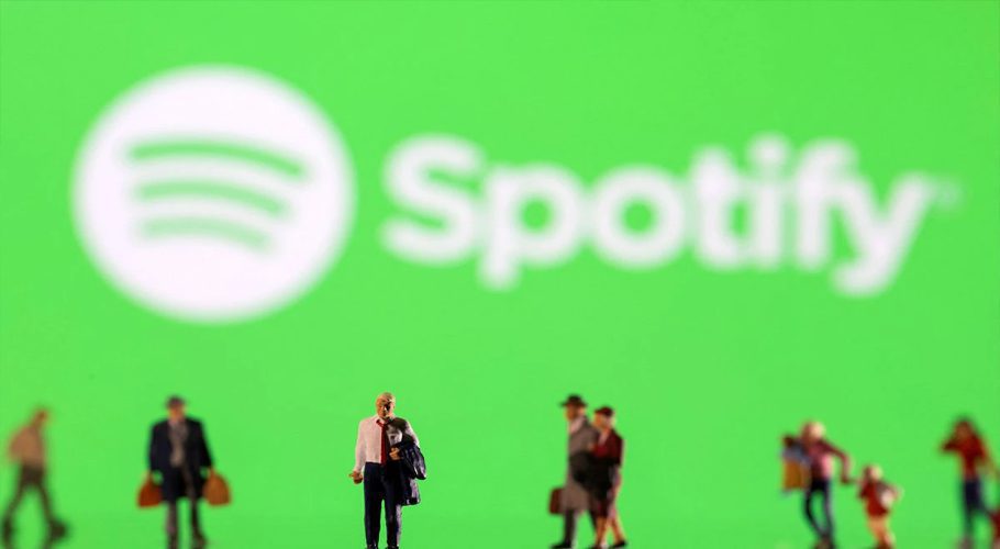 Small figurines are seen in front of displayed Spotify logo in this illustration taken February 11, 2022. REUTERS/Dado Ruvic/Ilustration