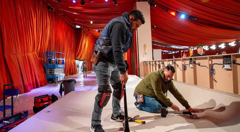 A section of champagne-colored carpet is installed under an orange tent during preparations for the Oscars. Credit...Noel West for The New York Times