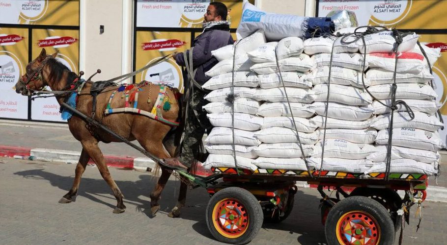 A Palestinian loads a cart with aid food provided by the UN's World Food Programme and its agency for Palestinian refugees, UNRWA, in the Gaza Strip's al-Shati refugee camp on December 23, 2020 [Majdi Fathi/NurPhoto via Getty Images]