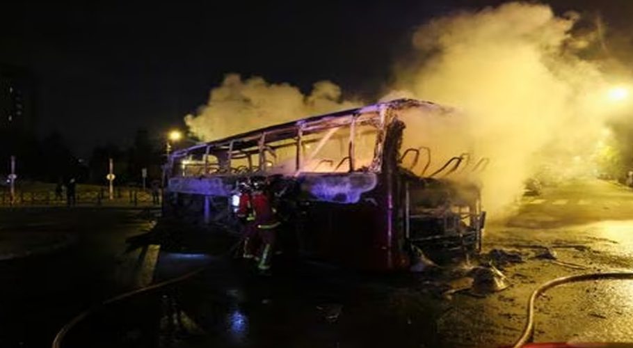 Firefighters use a water hose on a burnt bus as unrest continues following the death of a 17-year-old teenager killed by a French police officer during a traffic stop, in Nanterre, Paris suburb, France, July 1, 2023. REUTERS/Yves Herman