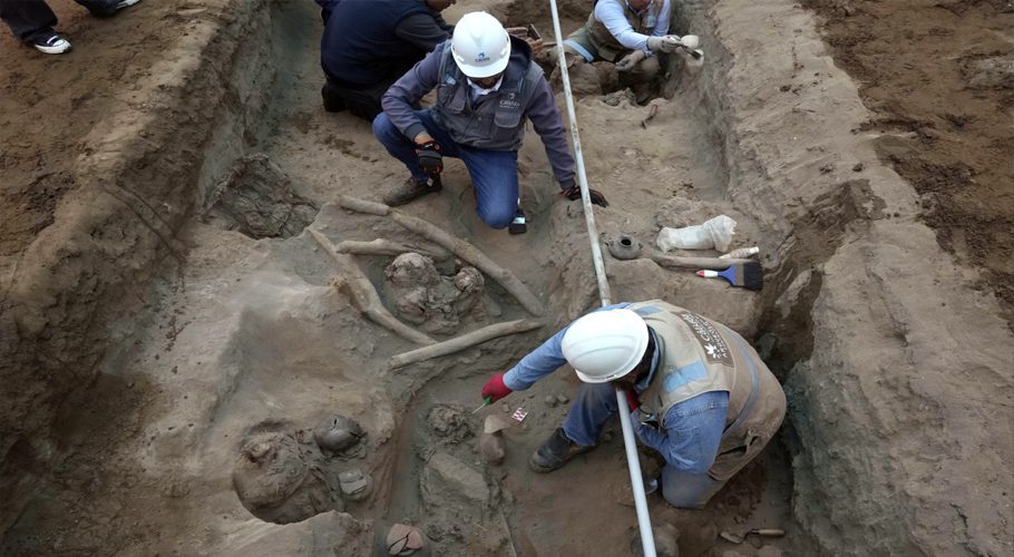 Archaeologists uncover bones and vessels discovered by city workers who were digging a natural gas line for the company Calidda in the district of Carabayllo on the outskirts of Lima, Peru, Friday, Sept. 22, 2023. Eight burial offerings from the pre-Inca Ychsma culture have been identified by archeologists so far, according to lead archeologist Jesus Bahamonde. The tube running through the site is an illegal water pipe. (AP Photo/Martin Mejia)