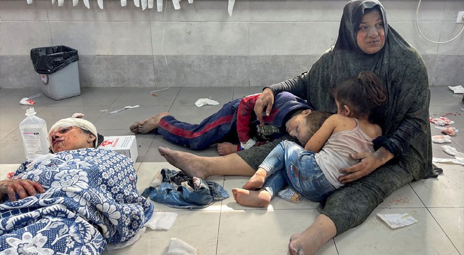 A Palestinian woman holds her children, who were wounded along with her in an Israeli strike, at Shifa hospital in Gaza City, October 23. REUTERS/Mohammed Al-Masri