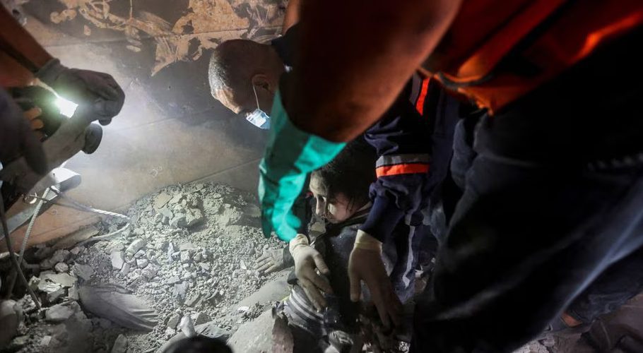 Emergency personnel work to rescue a Palestinian girl at the site of Israeli strikes on a residential building, amid the ongoing conflict between Israel and Palestinian Islamist group Hamas, in Khan Younis in the southern Gaza Strip, November 7, 2023. REUTERS/Ahmed Zakot Acquire Licensing Rights