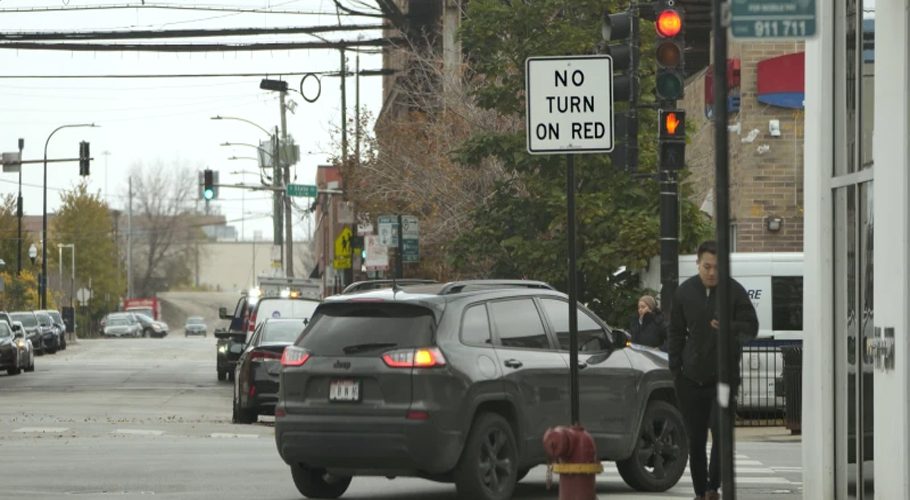 A passenger vehicle makes a right turn on red at an intersection that prohibits the turn Tuesday, Oct. 31, 2023, in Chicago. (AP Photo/Charles Rex Arbogast)