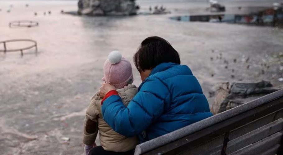 A woman and a child sit in a park in Beijing, China January 12, 2024. REUTERS/Tingshu Wang/file photo Acquire Licensing Rights