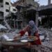 A Palestinian woman prepares a traditional Ramadan iftar meal amid the ruins of her family’s house. Photo: AFP