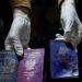 A man displays blood-stained British, Polish, and Australian passports after an Israeli airstrike, in Deir al-Balah, Gaza Strip, April 1, 2024. (AP Photo/Abdel Kareem Hana)
