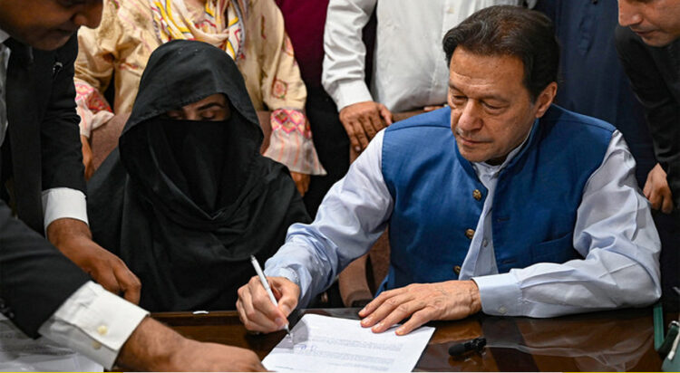 Pakistan's former Prime Minister, Imran Khan (R) along with his wife Bushra Bibi (L) looks on as he signs surety bonds for bail in various cases, at a registrar office in the High court, in Lahore on July 17, 2023. (AFP/File)