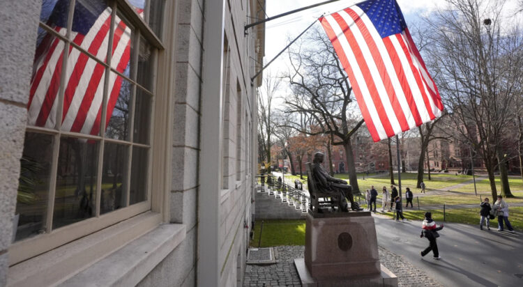 People walk past the John Harvard statue in Harvard Yard, Tuesday, Dec. 17, 2024, on the campus of Harvard University in Cambridge, Mass. (AP Photo/Steven Senne)