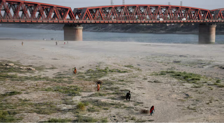 People walk on the dry riverbed of the Indus River in Hyderabad, Pakistan April 24, 2025. REUTERS/Yasir Rajput/File Photo