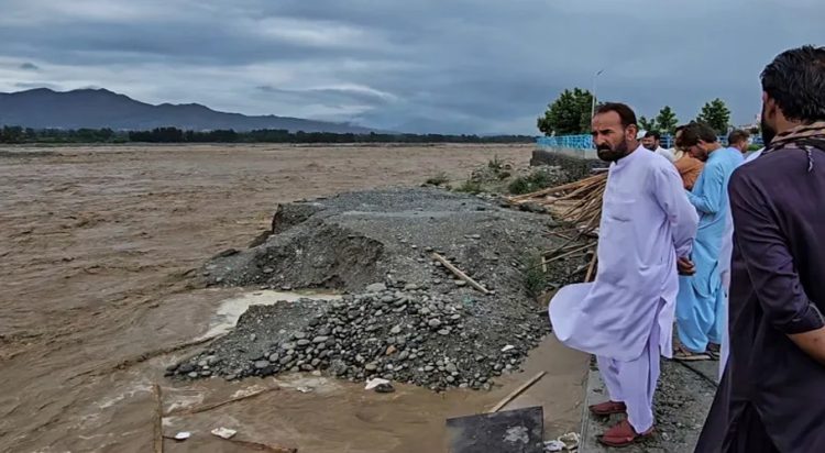 File/ Local residents at the Swat River, which is overflowing due to pre-monsoon heavy rains in the area on the outskirts of Mingora, the main town of Pakistan's Swat Valley [Sherin Zada/AP]