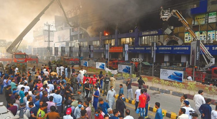This file phot shows rescue 1122 firefighters trying to put out a blaze at Hafeez Centre on main Boulevard Gulberg on October 10, 2020. (Image: M. Arif / White Star via Dawn.com)