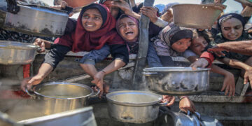 People wait to receive hot meals in Gaza this month. Photograph: Anadolu/Getty Images