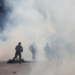 Police officers and supporters of Tehreek-e-Labbaik Pakistan (TLP) run amid tear gas fired by police during a solidarity march for Gaza in Lahore on October 10. — Reuters