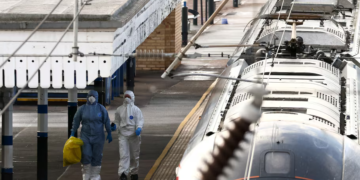 Forensic officers walk next to the London North Eastern Railway (LNER) train where a series of stabbings took place, at a platform at Huntingdon Station, near Cambridge, Britain, November 2, 2025. REUTERS/Jack Taylor