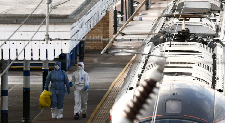 Forensic officers walk next to the London North Eastern Railway (LNER) train where a series of stabbings took place, at a platform at Huntingdon Station, near Cambridge, Britain, November 2, 2025. REUTERS/Jack Taylor