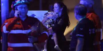 A woman a child in a blanket after a shooting incident at Bondi Beach in Sydney on December 14. — AFP