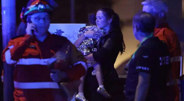 A woman a child in a blanket after a shooting incident at Bondi Beach in Sydney on December 14. — AFP