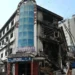 Paramilitary personnel walk past charred remains of the Gul Plaza shopping mall in Karachi on Jan 22, 2026. — AFP