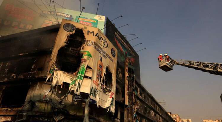 Firefighters work next to smouldering remains following a massive fire at the Gul Plaza Shopping Centre in Karachi, on Jan 19, 2026. — Reuters