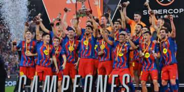 Football - Spanish Super Cup - Final - FC Barcelona v Real Madrid - King Abdullah Sports City Stadium, Jeddah, Saudi Arabia - January 12, 2026 FC Barcelona's Ronald Araujo lifts the trophy with teammates after winning the Spanish Super Cup final REUTERS/Stringer