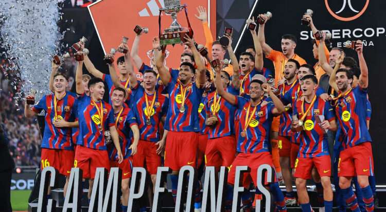 Football - Spanish Super Cup - Final - FC Barcelona v Real Madrid - King Abdullah Sports City Stadium, Jeddah, Saudi Arabia - January 12, 2026 FC Barcelona's Ronald Araujo lifts the trophy with teammates after winning the Spanish Super Cup final REUTERS/Stringer
