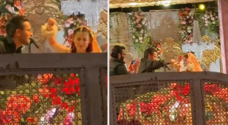 Hania Aamir can be seen wearing a bright yellow outfit with floral hand garlands, matching the festive mood of a traditional Mayun ceremony, while Asim Azhar grooves enthusiastically in a black outfit (Screengrab)