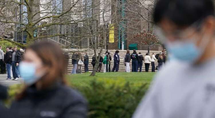 Students line up for antibiotics outside a building at the University of Kent in Canterbury, England, on Monday. The university confirmed that a student was one of two people who have died as a result of meningitis in the area. Gareth Fuller/PA/AP