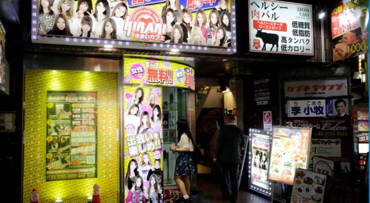 A young woman hovers in the doorway of one of Kabukicho’s information centres, which give recommendations for bars and sex shops. Photograph: Kosuke Okahara/The Guardian