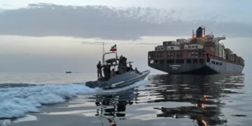 An IRGC boat approaches a cargo vessel in the Strait of Hormuz [File: Tasnim via AFP]